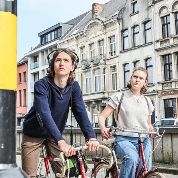 jongen en meisje op de fiets voor het rode licht