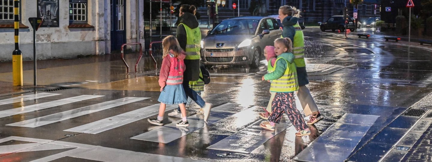 voetgangers in fluohesjes die oversteken op een zebrapad