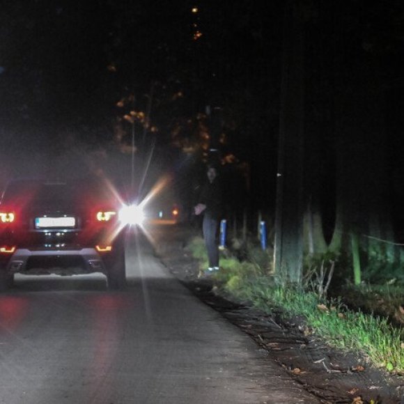 voetganger en auto op donkere weg