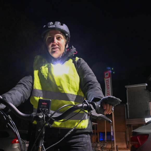 fietser met losse fietsverlichting op borst, wit voorlicht